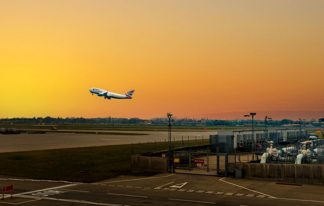 Aircraft taking off from Heathrow at sunset, cheapest way to the airport at Christmas