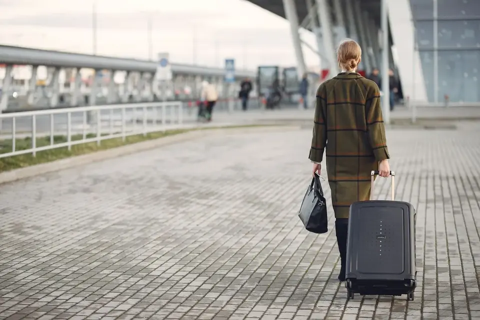 Traveller with a suitcase outside an airport terminal